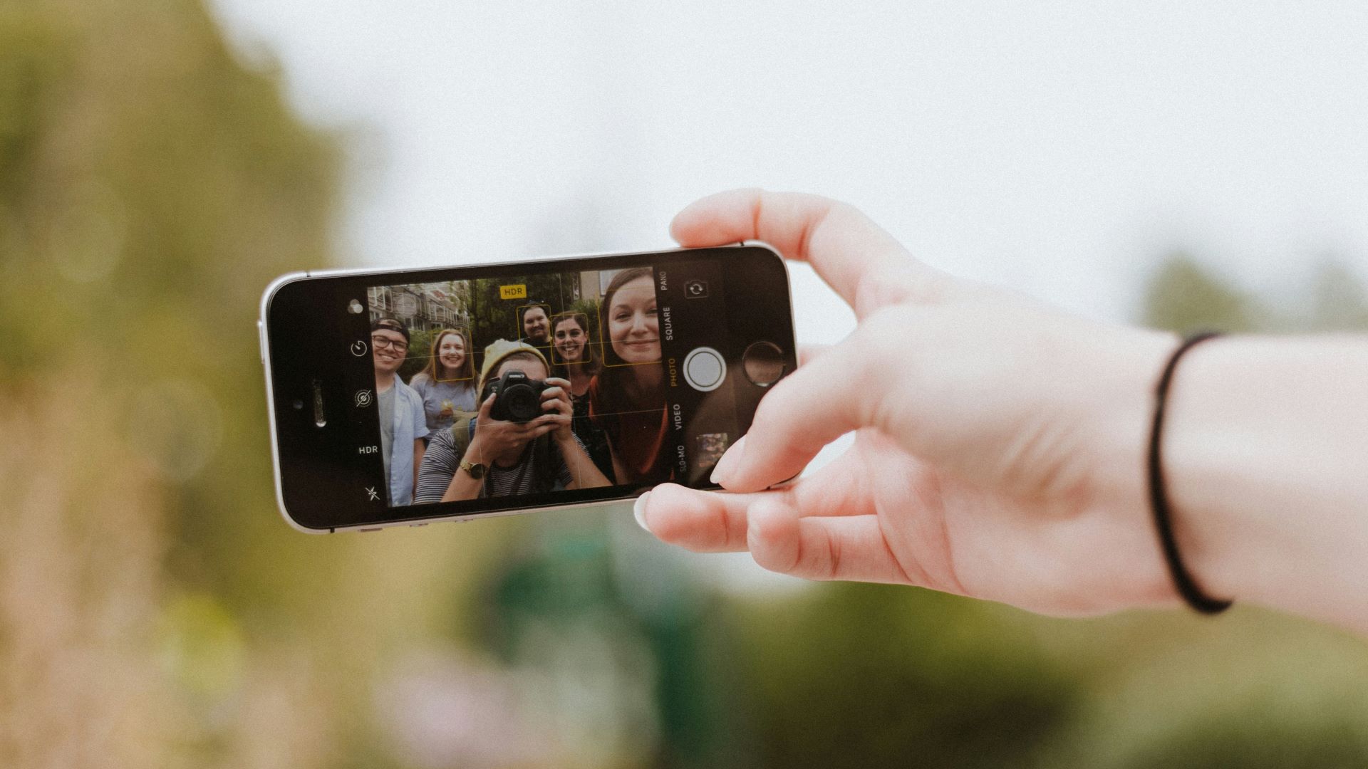 En liten gruppe mennesker som tar en "selfie" sammen på en iPhone.